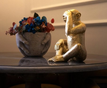 Golden sculpture and flowers on a marble table